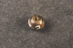 Small, colorful glass beads like this one were common trade items offered by European colonists to Native Americans, especially for furs.