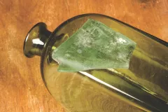 Square bottles of green glass were made to be easily transported. The bottles were placed inside wooden boxes with dividers for safekeeping.